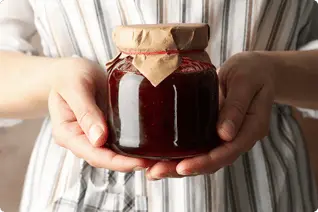 余市産フルーツを使った無添加ジャムを手に持ち、丁寧なものづくりを表現した製造風景